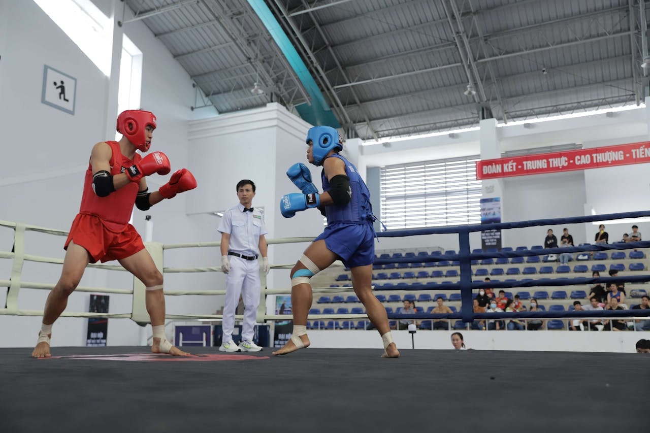 Crafting Captivating Headlines: Your awesome post title goes here Two athletes spar in a boxing ring, overseen by a referee, inside a modern sports arena.
